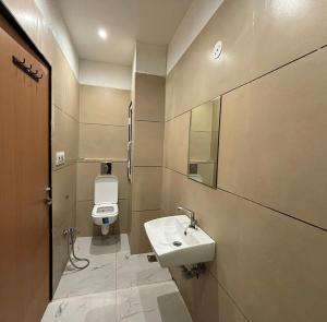 a bathroom with a white sink and a toilet at Hotel The Sun B&B in New Delhi