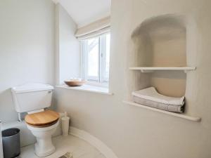 a bathroom with a toilet and a window at The Nest in Lyme Regis +30 photos