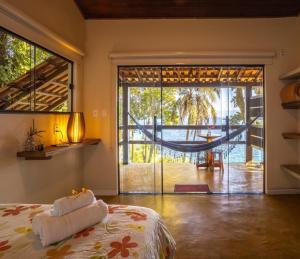 a bedroom with a bed and a large sliding glass door at Pousada Lagamar in Praia Vermelha
