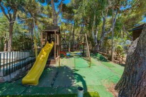 a playground with a yellow slide in a park at Camping Villaggio Egad in Favignana