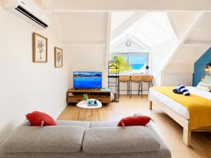 a living room with two beds and a couch at Studio Coconut in Baie Nettle