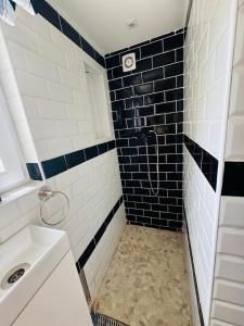 a bathroom with black and white tiles and a sink at Csillagkapu Vendégház in Kápolnásnyék +46 photos