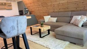 a living room with a couch and a table at Fészek Lombház in Kismaros +8 photos