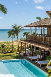 a view of a resort with a swimming pool and the ocean at Hurricane Jeri in Jericoacoara