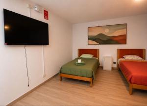 a room with two beds and a flat screen tv at MyAbancayHome in Abancay