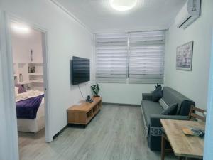 a living room with a couch and a tv and a bed at Medano Time in El Médano