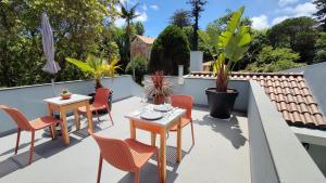 a patio with tables and chairs on a roof at Victória Guest House in Furnas