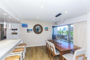 a dining room with white walls and a wooden table and chairs at Ilikai Tower 525 in Honolulu
