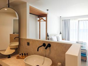 a bathroom with a sink and a large mirror at Aeolia Seaside Hotel in Kardamaina +79 photos
