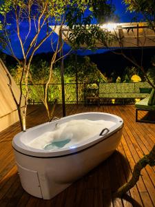 a bath tub sitting on top of a deck at Chalé Canto do Rio - Vale do Capão in Palmeiras