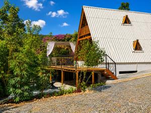 a house with a deck next to a building at Chalé Canto do Rio - Vale do Capão in Palmeiras