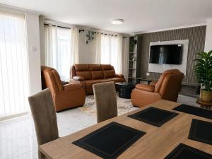 a living room with a table and chairs and a television at Shawn's Hub in Ruaka