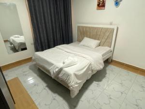 a small bed in a room with a mirror at Shawn's Hub in Ruaka