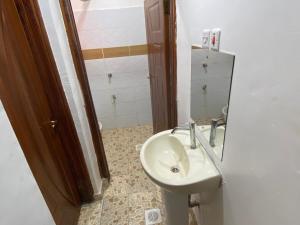 a bathroom with a sink and a mirror at Shawn's Hub in Ruaka +8 photos