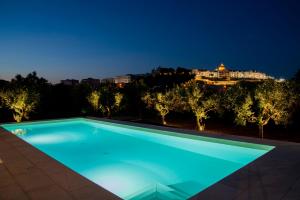 a swimming pool at night with a building in the background at Masseria Trulli Bruni in Locorotondo