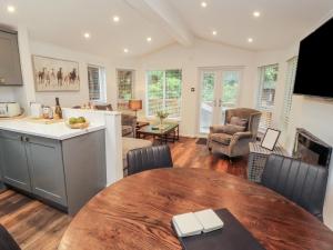 una cucina e un soggiorno con un tavolo in legno di Willows Lodge a Windermere