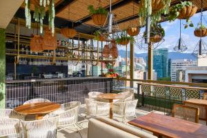 a restaurant with tables and chairs on a balcony at Golden Valley Hotel in Medellín