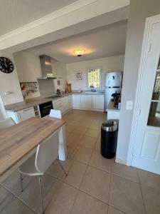 a kitchen with white cabinets and a wooden counter top at Villa les Coralines in Les Issambres +16 photos
