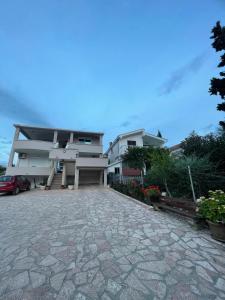 a house with a stone driveway in front of it at Asijaapartmani in Bar