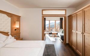 a hotel room with two beds and a balcony at Parkhotel Holzerhof in Maranza +29 photos
