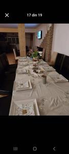 a long table with plates and wine glasses on it at Vila Mihnea in Moieciu de Jos