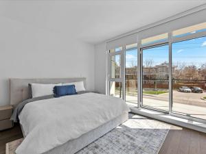a bedroom with a bed and a large window at Gyrobeach Getaway in Kelowna +97 photos