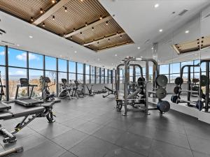 a gym with treadmills and machines in a room with windows at Gyrobeach Getaway in Kelowna