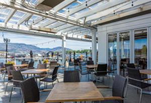 a patio with tables and chairs and windows at Gyrobeach Getaway in Kelowna