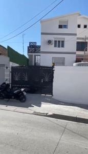a motorcycle parked in front of a black fence at Oli House 3 in Durrës +7 photos
