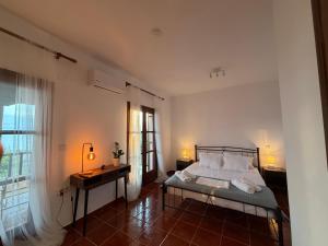a bedroom with a bed and a desk and a window at Athos Sea Villa in Ouranoupoli