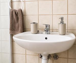 a white sink in a bathroom with tiled walls at CAVE Properties Group in Pionierspark +20 photos