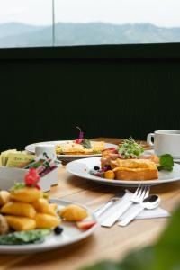 a wooden table with plates of food on it at Golden Valley Hotel in Medellín