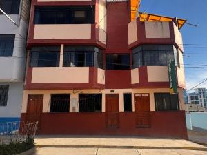 a red and white building with brown doors at MyAbancayHome in Abancay