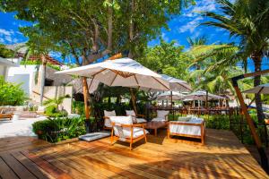 a wooden deck with a table and chairs and an umbrella at Quiya Beach Residences in Cruz de Huanacaxtle