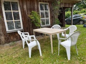 a wooden table and four chairs in front of a house at Vestervang 1, 8654 Bryrup in Bryrup +19 photos