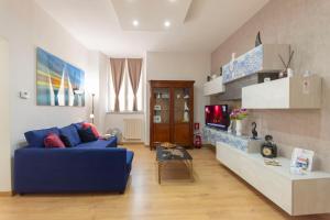 a living room with a blue couch and a tv at DOMUS 73 Apulian holidays in Barletta