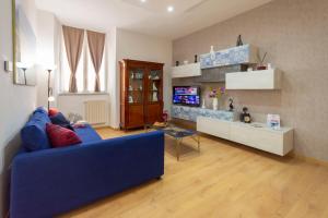 a living room with a blue couch and a tv at DOMUS 73 Apulian holidays in Barletta