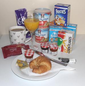 une table avec une assiette de nourriture et un verre de jus d'orange dans l'établissement The Annex - Easter Arr, à Auldearn