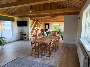 a dining room with a wooden table and chairs at Dizrobeznieki in Veldze