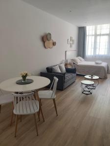 a living room with a table and a couch at apartamentos YEIK in Muxia