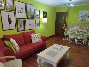 a living room with a red couch and a table at Apartamento El Ferial in Sarón