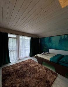 a bedroom with a bed and a large window at FoxHome in Khashchovanoye