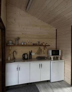 a kitchen with white cabinets and a microwave at FoxHome in Khashchovanoye