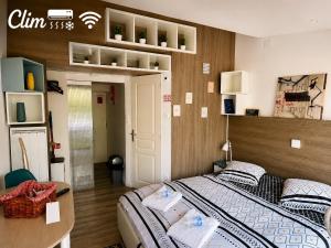 a bedroom with two twin beds and a desk at Aux Lofts de VERDUN in Verdun-sur-Meuse