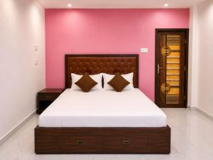 a bedroom with a large bed with a pink wall at Hotel Eva Palace in Chatra