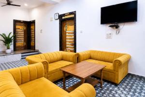 a living room with couches and a table and a tv at Hotel Eva Palace in Chatra