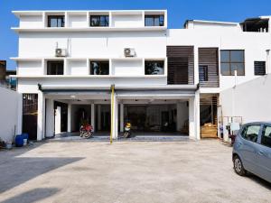 a white building with a car parked in front of it at Hotel Eva Palace in Chatra