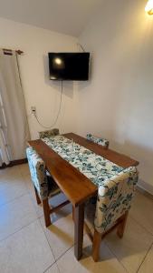 a wooden table with a chair and a television on the wall at Sol del Valle in Mina Clavero
