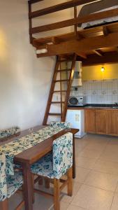 a kitchen with a wooden table and chairs and a ladder at Sol del Valle in Mina Clavero