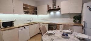 a kitchen with a table with plates and wine glasses at Apartment Nereo in Senj